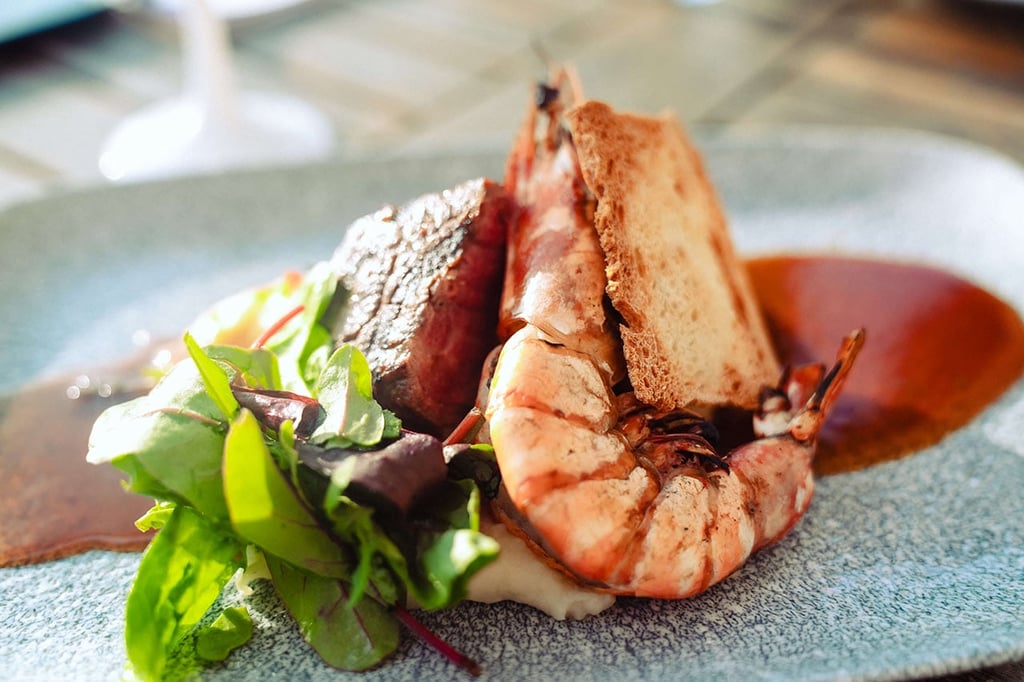Exquisite main course from the Italian restaurant Al Porto, featuring beef tenderloin and king prawns.