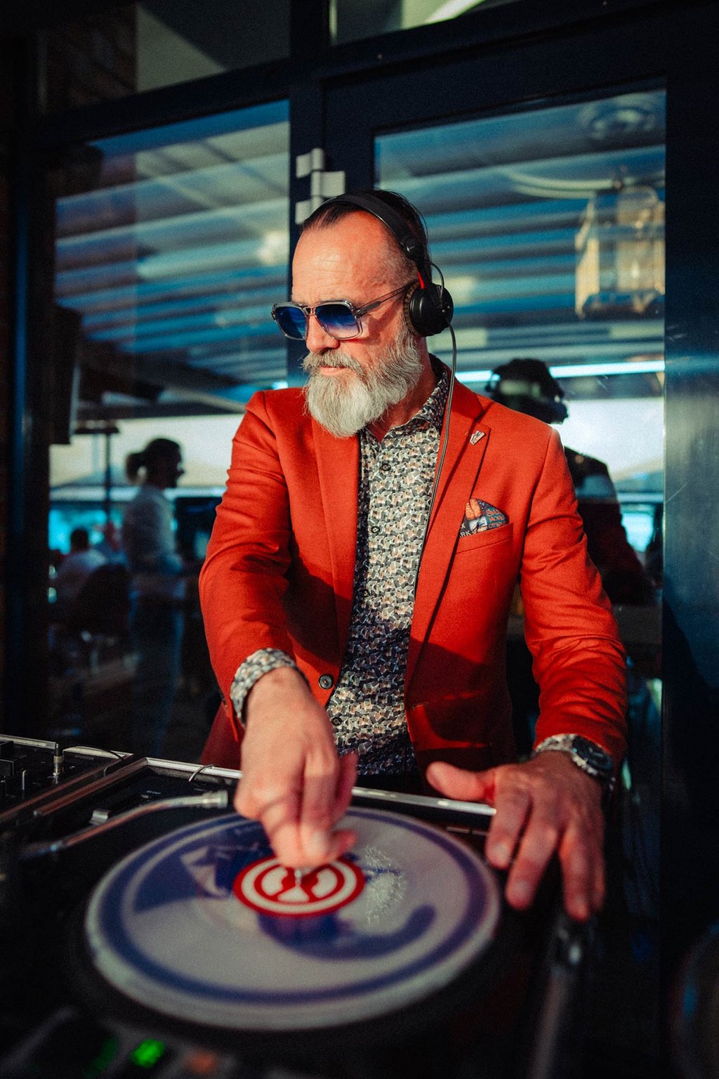 Live-DJ im roten Sakko sorgt für ausgelassene Partystimmung im Restaurant Al Porto bei einer Veranstaltung.
