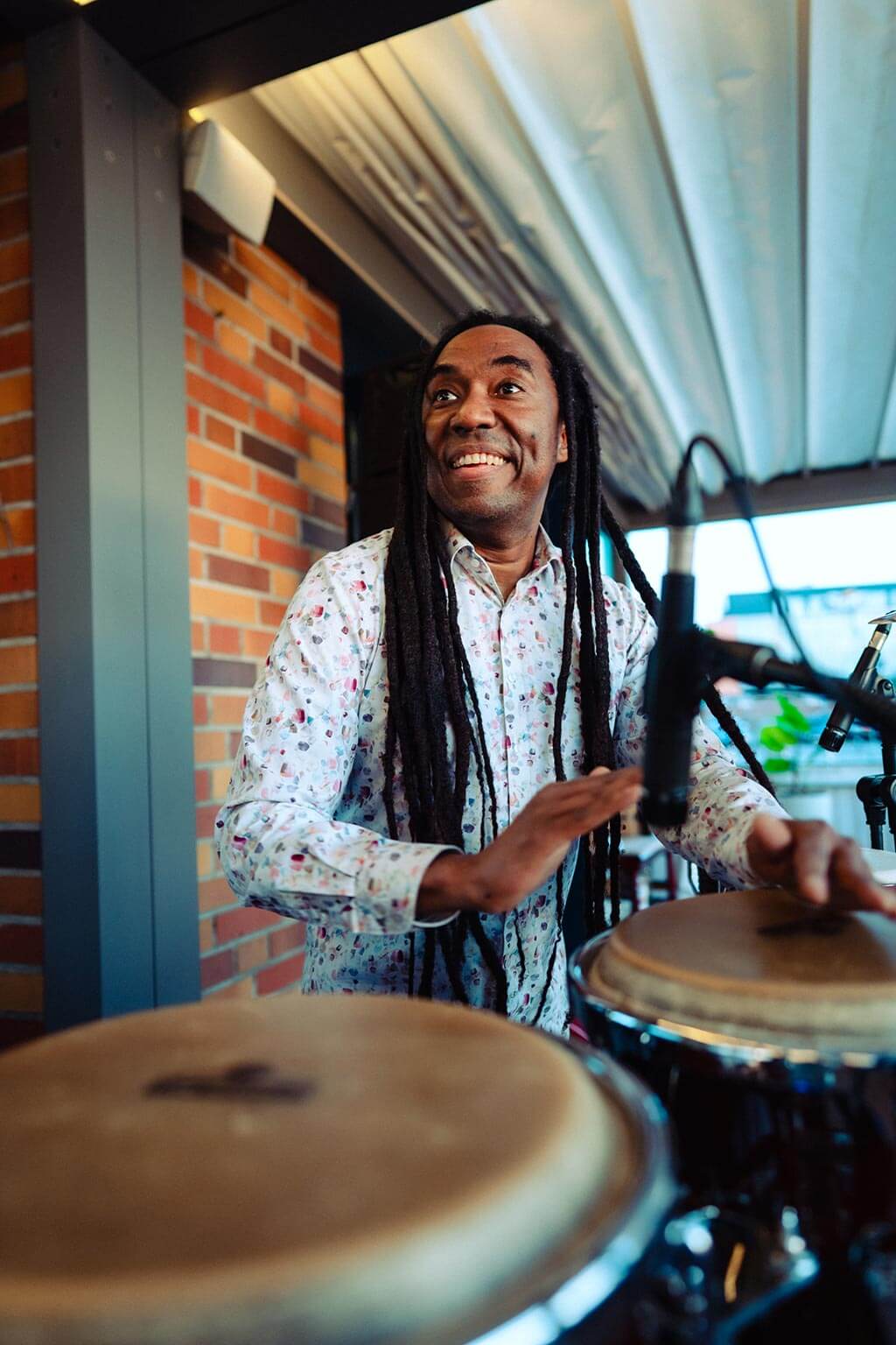 Live musician cheerfully plays a tambourine at a live event at Al Porto.