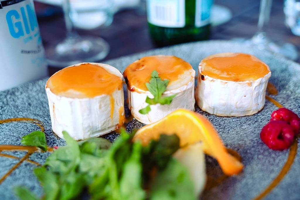 Vorspeise mit gratiniertem Ziegenkäse, serviert mit Rucola, Orange und Himbeeren, Frist vom Italiener in Rostock.